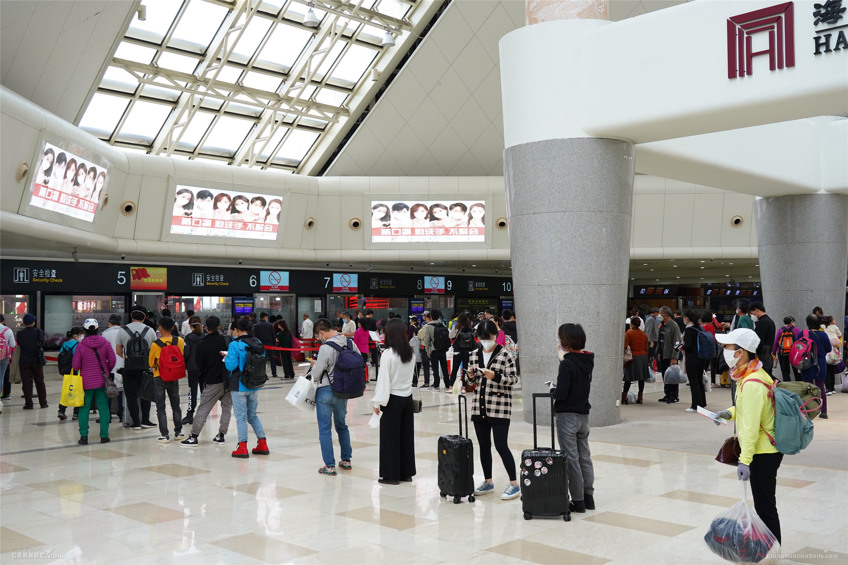 氣溫攀升 客流回暖 海口美蘭(lan) 國際機場戰“疫”複工兩(liang) 手抓